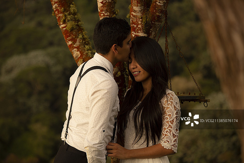 年轻情侣站在树旁互相拥抱图片素材