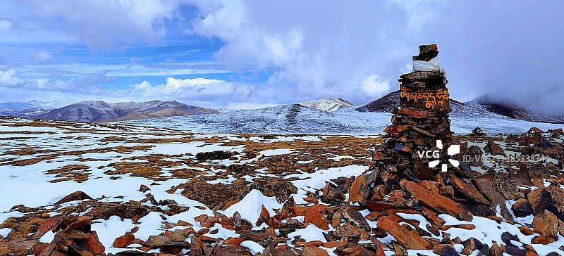 冬季是雪的季节，雪山顶上的玛尼堆和六字真言图片素材