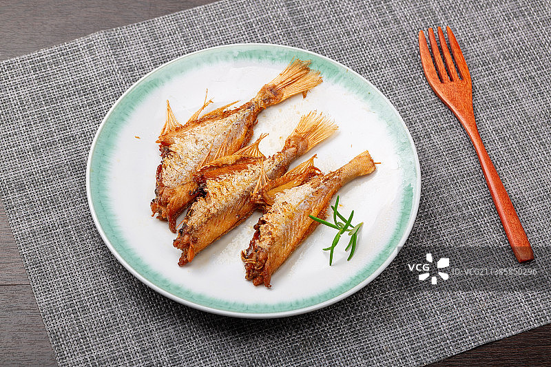 盘子里的三条咸鱼小菜图片素材