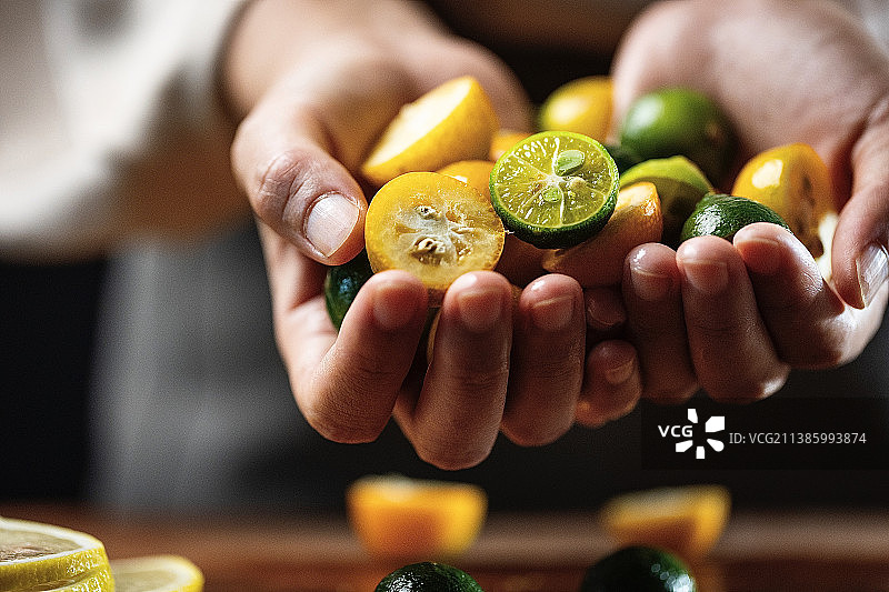 手捧着小青柠和小金桔图片素材