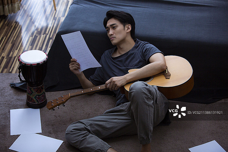吉他手在家创作音乐看乐谱图片素材