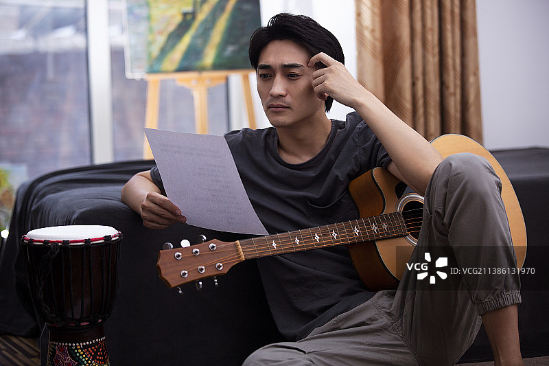 吉他手在家创作音乐看乐谱图片素材