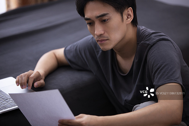 年轻男子在家使用笔记本电脑工作图片素材