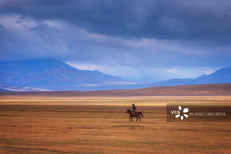 一个人在中国新疆禾木草原上驰骋图片素材