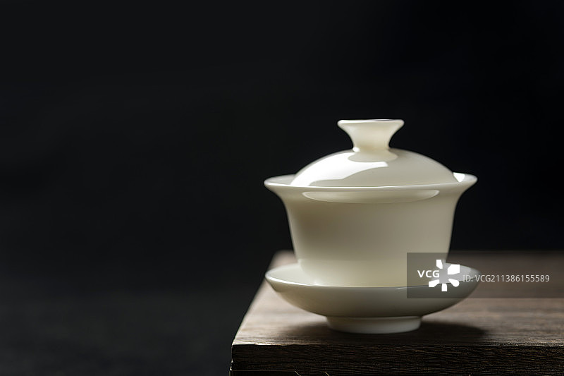 白瓷三才杯盖碗特写木桌面黑色背景图片素材