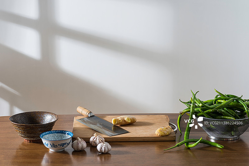 桌面上的青椒大蒜生姜等调味料和厨具及餐具图片素材