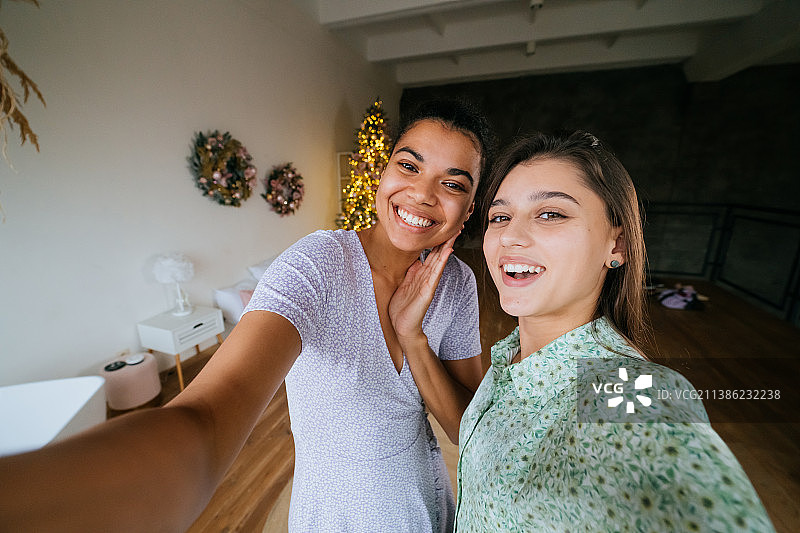 两个女孩在客厅里自拍。图片素材