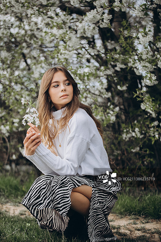 春日人像：乌克兰盛开花园中的卷发少女图片素材