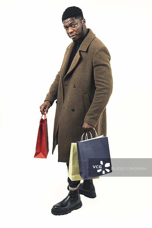 黑人男顾客手提购物袋，白色背景全身照图片素材