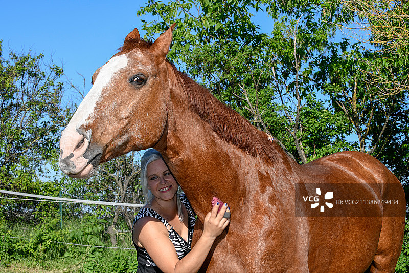 微笑的女人和纯种马的肖像图片素材