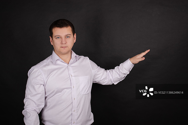 黑色背景上穿白衬衫的英俊男子肖像图片素材