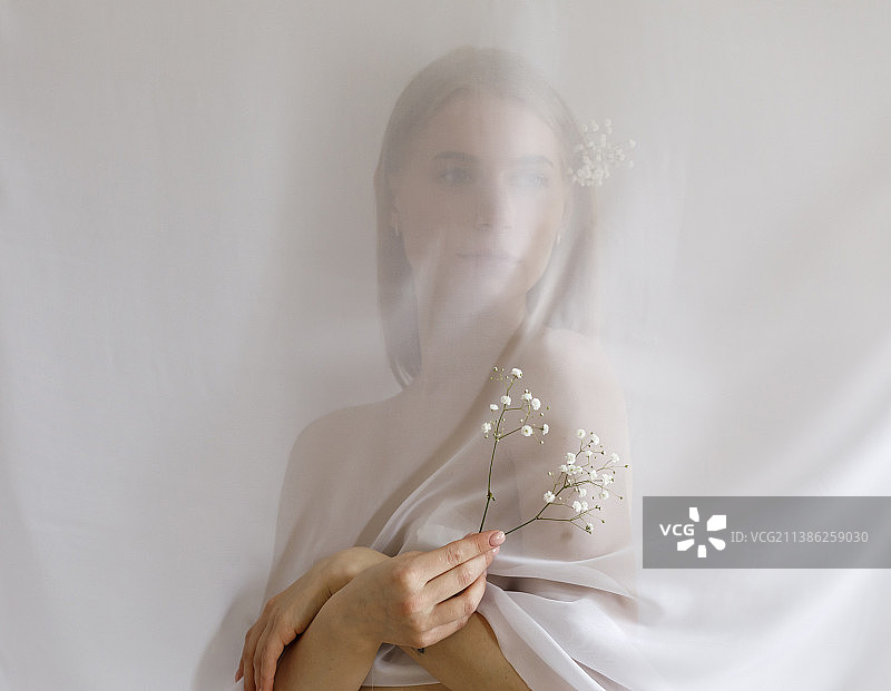 裹着薄纱的时尚年轻漂亮女人在工作室的肖像图片素材