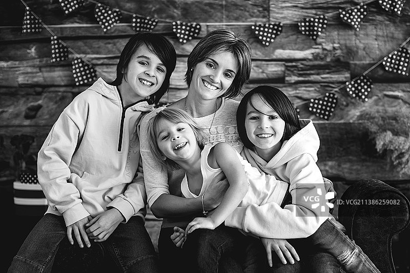 温馨的母亲和三个男孩的家庭照与情人节装饰图片素材