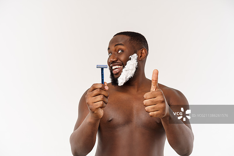 年轻的非裔美国男人在浴室刮胡子，进行日常晨间护理图片素材