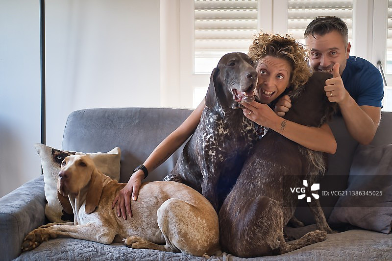 幸福的一家：男人和狗一起坐在家里的沙发上图片素材