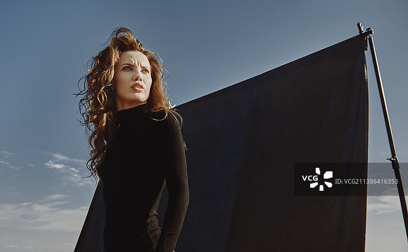 户外身穿黑色紧身衣的年轻女子，背景为海洋图片素材