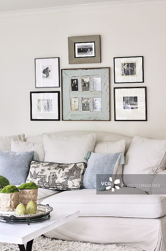 浅色乡村别墅沙发上的黑白照片和靠垫图片素材