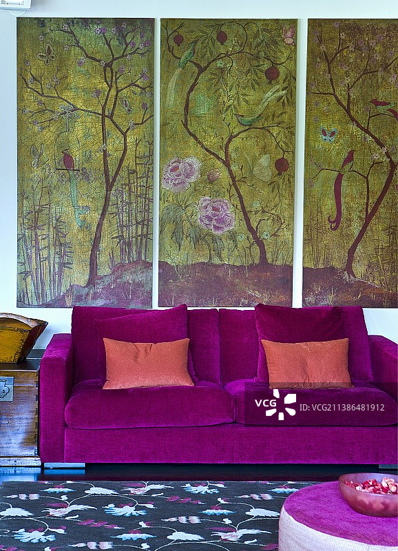 墙上挂着风景三联画的紫色天鹅绒现代沙发图片素材