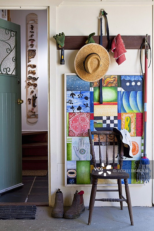 挂在乡村门厅衣架上的草帽和园艺工具图片素材
