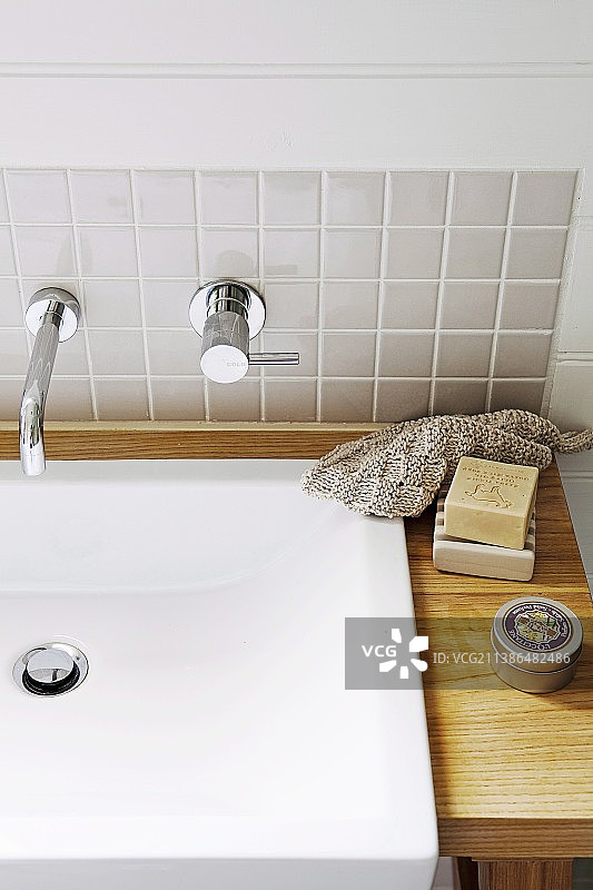 现代梳妆台：木质台面水槽和设计师墙壁水龙头图片素材