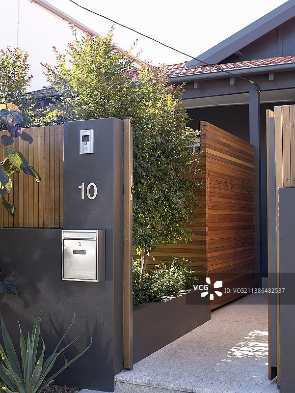 深灰色花园墙，带开放式大门和木制屏风图片素材