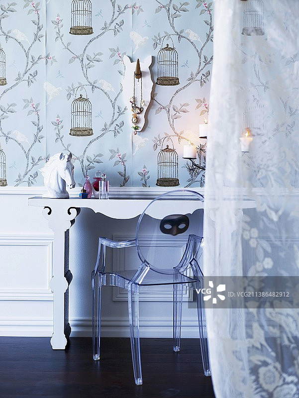 梳妆台上设计师设计的亚克力椅子和瓷马头，前景是浪漫的薄纱窗帘图片素材
