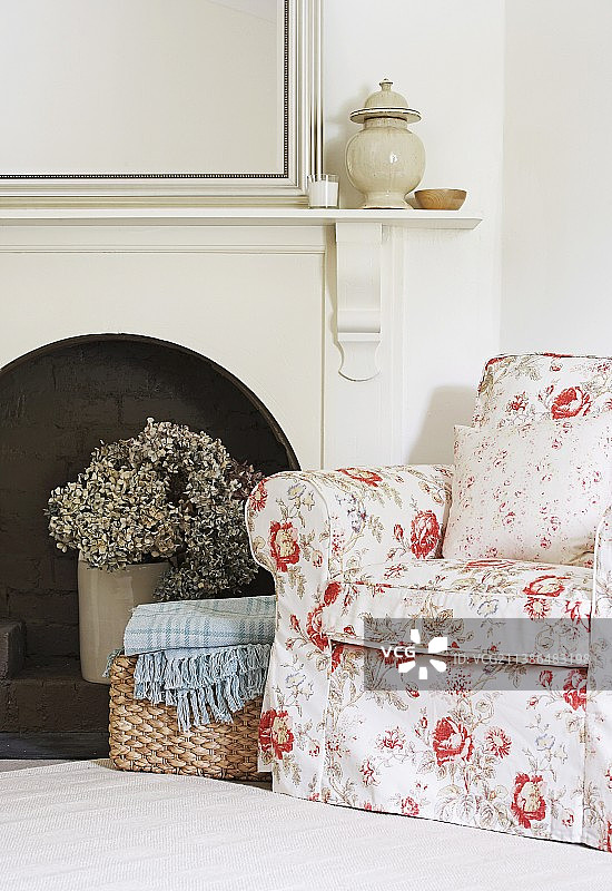 壁炉旁乡村风格的舒适座椅区，配有花卉图案的扶手椅图片素材