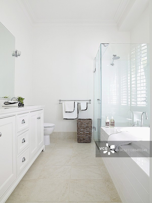 高挑的浴室：优雅白色乡村风格，配有玻璃淋浴隔断和石色瓷砖地板图片素材
