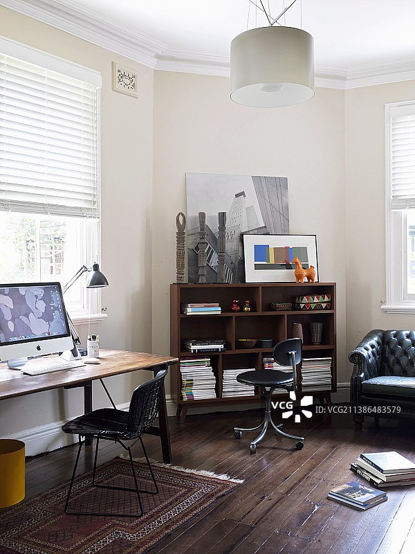 办公室内窗户下的桌子和复古椅子，百叶窗半闭，旁边是置物架图片素材