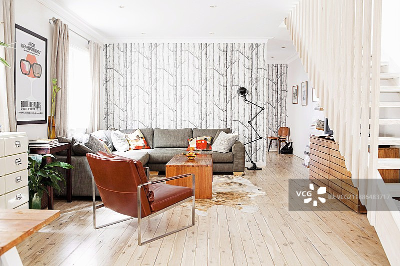 宽敞的室内设计，配有皮革扶手椅和灰色转角沙发图片素材