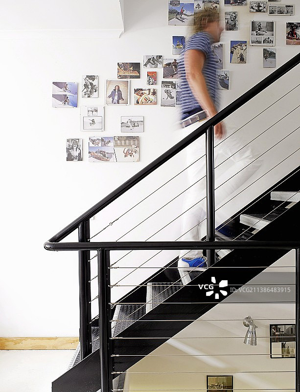 照片墙与黑色钢制楼梯，男人爬楼梯图片素材