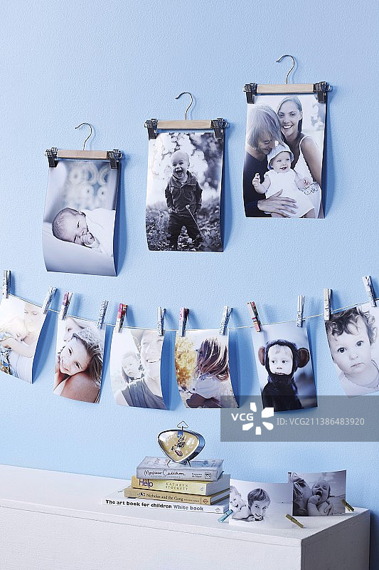 用迷你衣夹固定在绳子上的家庭照片，并悬挂在小衣架上图片素材