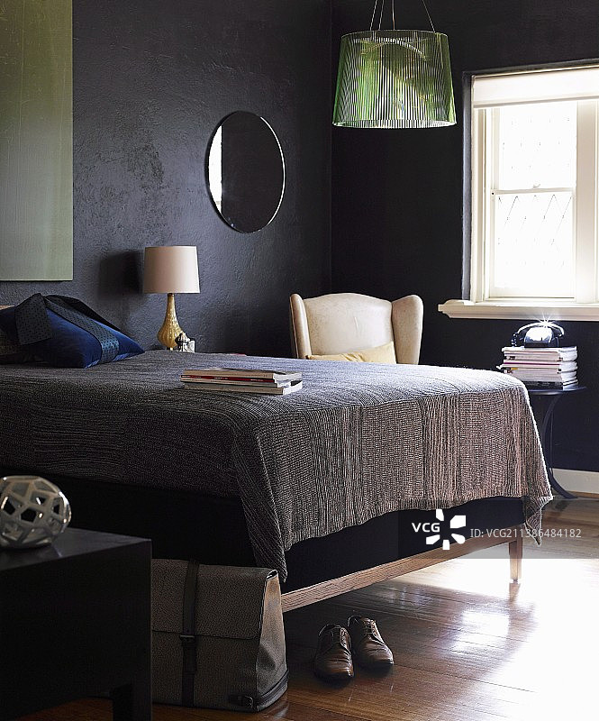 黑色墙壁小卧室里的高大软包床架双人床图片素材