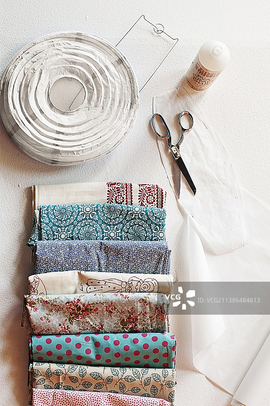 各种折叠的织物样品、白色纸灯笼、剪刀和胶水图片素材