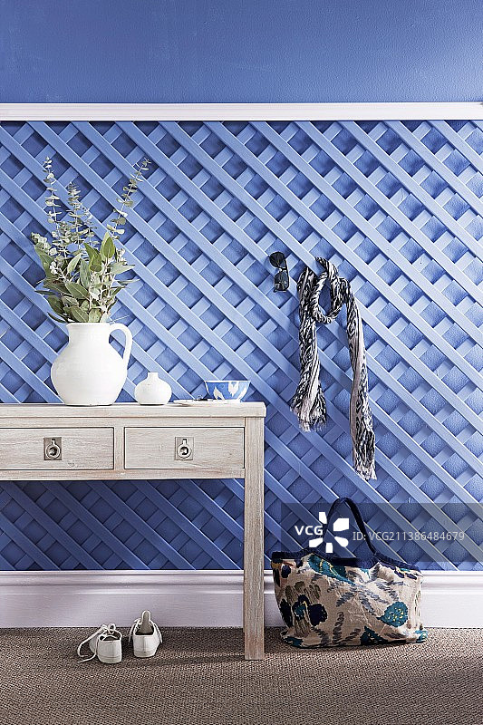 浅蓝色木制棚架，用作控制台桌子上装饰品后面的衣帽架图片素材