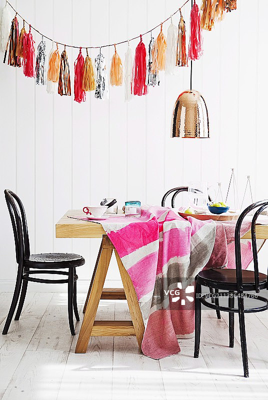 餐桌上的格子桌布、吊灯和闪亮纸穗花环图片素材