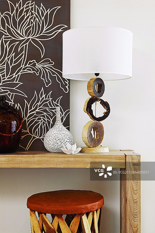 木桌上带有树枝切片和白色灯罩的艺术底座台灯图片素材