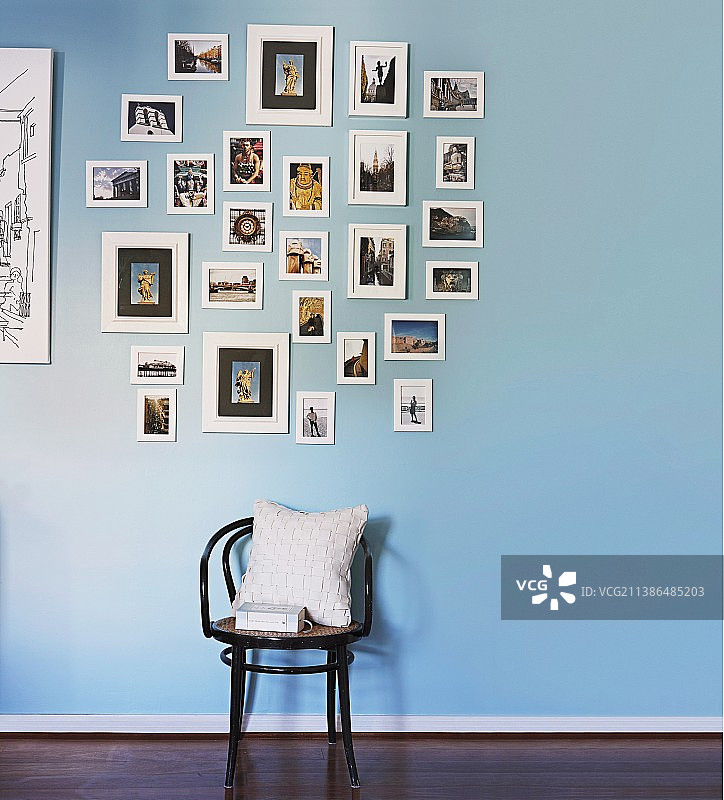 蓝色墙壁上图片收藏下方的白色软垫Thonet椅子图片素材