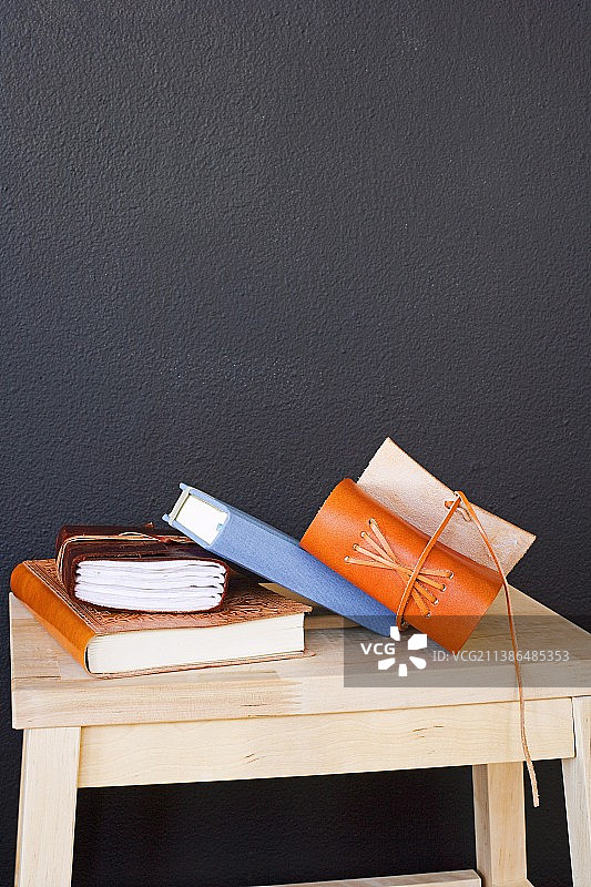 黑色墙前的木凳上的书籍图片素材