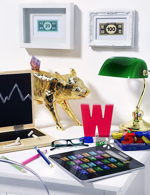 儿童房书桌，配有笔记本电脑形状的黑板、小猪存钱罐和iPad形状的计算器图片素材