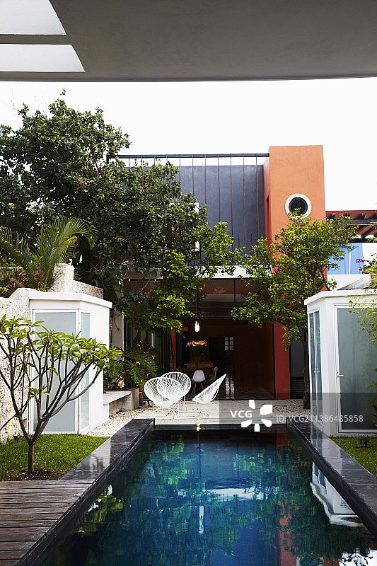 墨西哥房屋外露台上带有绳索座椅的泳池和贝壳椅图片素材