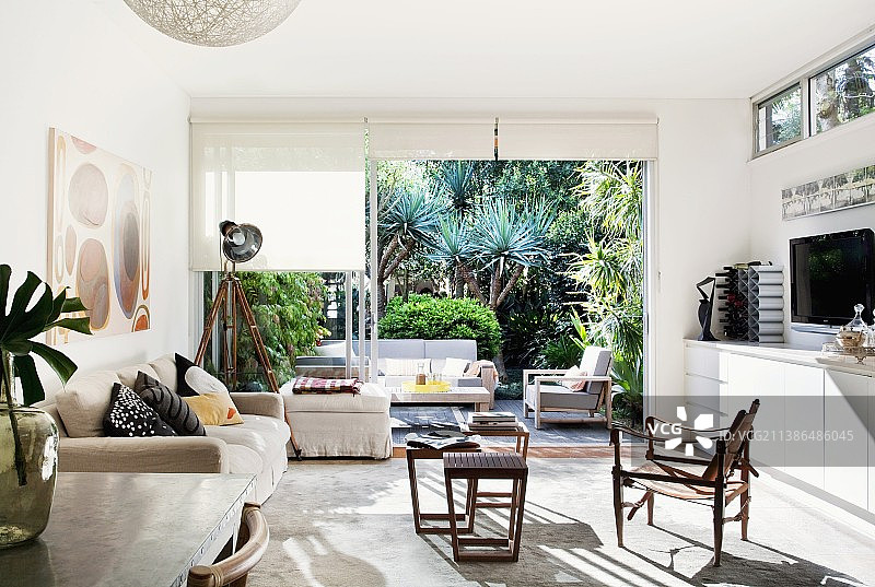 阳光明媚的开放式室内设计，带厨房台面、座位区，可欣赏到前面带丝兰的露台图片素材