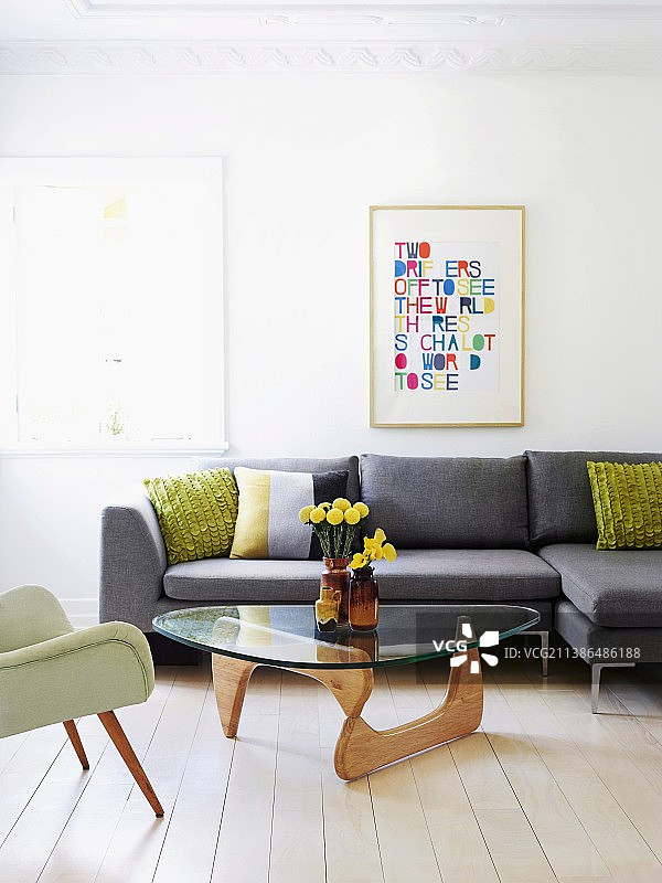 灰色沙发前和五十年代扶手椅旁的经典咖啡桌图片素材