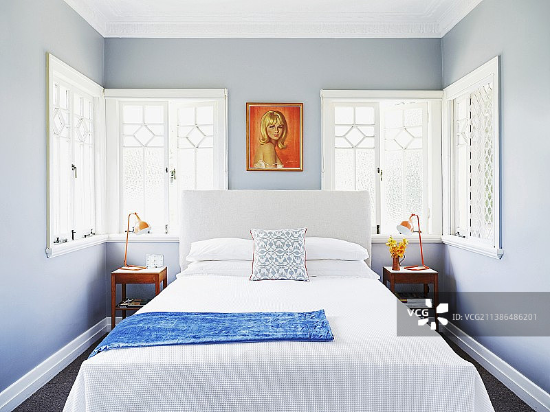 复古风画像下方的简约双人床，苍灰色墙壁卧室配有华丽窗户图片素材