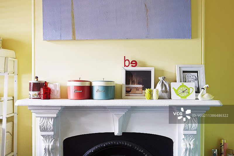 白色壁炉架上的储物罐，背景是淡黄色墙壁图片素材