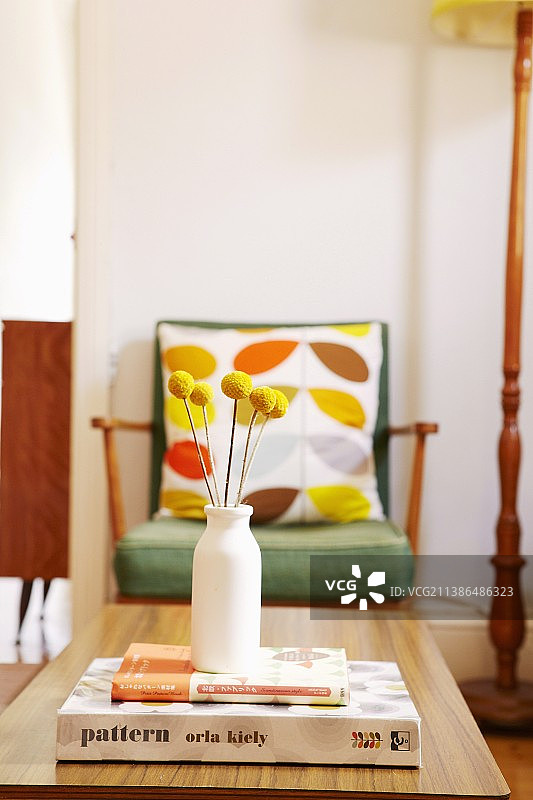 书本咖啡桌上的黄色干花花瓶和50年代扶手椅图片素材