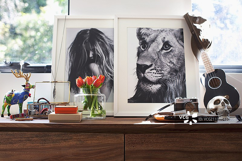 女性和男性装饰品在窗前餐具柜上的排列图片素材