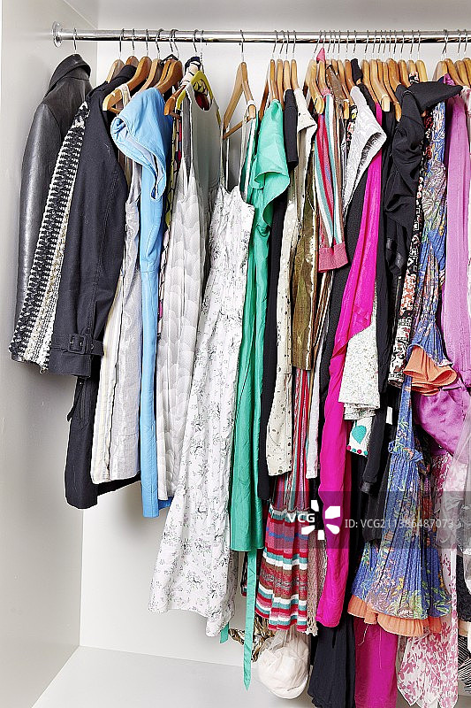 开放式衣柜中挂在衣架上的女装图片素材