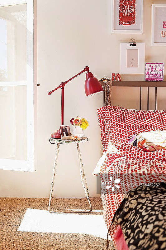 波点床单床边的复古凳子和红色复古落地灯图片素材