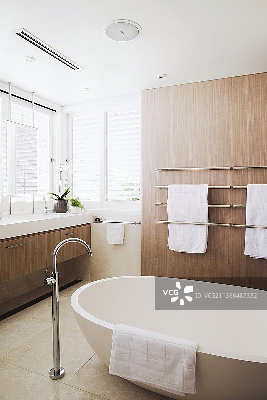 带浅色木镶板、石砖地板和现代独立浴缸的浴室图片素材